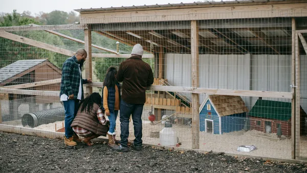 Family visiting an educational farm with animals outdoors