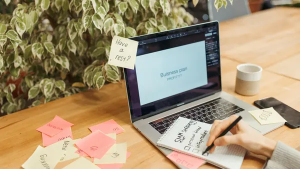 Workspace with laptop, sticky notes, and notepad for business planning