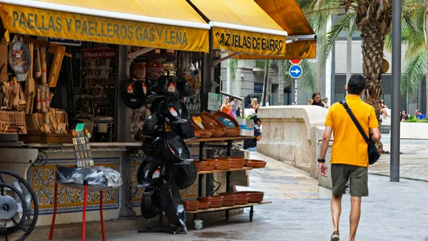 Local market in Spain with product stalls under colourful awnings