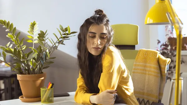 Persona treballant amb un portàtil en una oficina lluminosa amb plantes
